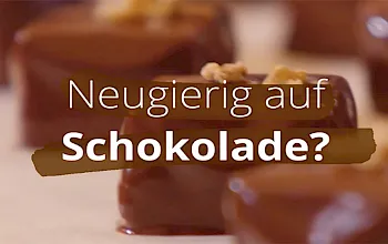 Verschwommene Pralinen mit dem Schriftzug "Neugierig auf Schokolade?"
